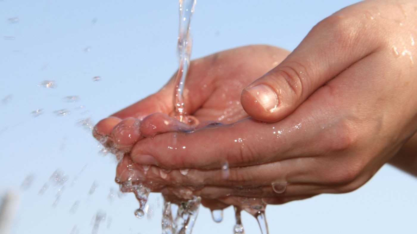 Hände unter Wasserstrahl