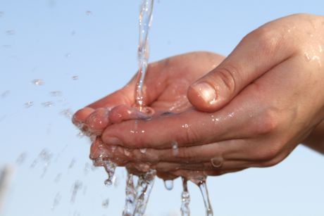 Hände unter Wasserstrahl